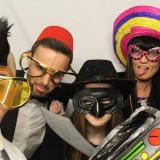 Group of friends dressing up in props inside a photo booth at a wedding in Wimbledon
