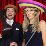 Couple having photos taken inside a green screen photo booth at a party in Wimbledon, London