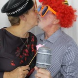 Couple capturing a sneaky kiss in a photo booth hired from Animation Events